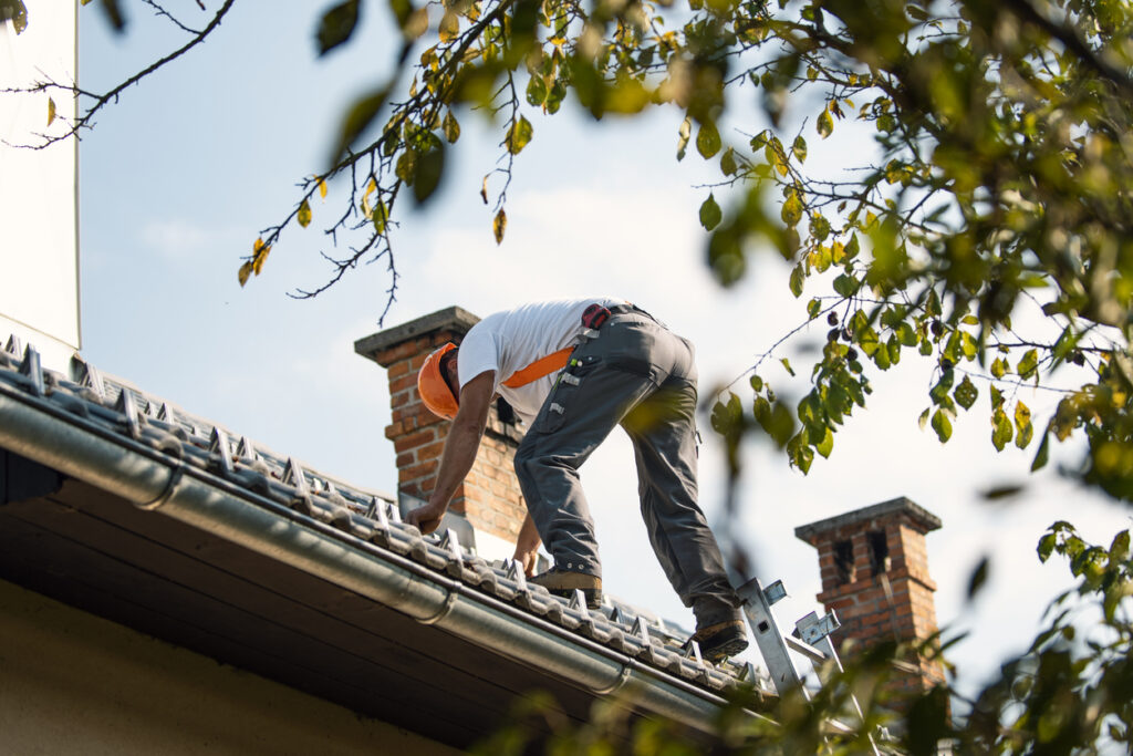 Photo d'un ouvrier entrain de poser des cales sur une toiture en tuiles